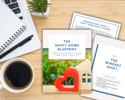 A flat lay of a notebook, coffee cup, succulent, and "The Happy Home Blueprint: A Simple Guide to a Calmer, More Joyful Family Life" by Wondermom Shop—ideal inspiration for busy moms craving peace at home.