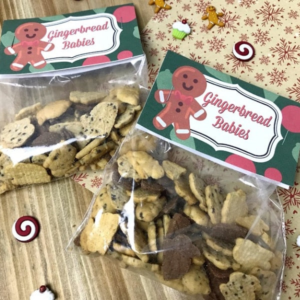 Two bags of VIP Vault Gingerbread Babies Treat Bags are displayed on a table, exuding Christmas cheer. These VIP Vault Gingerbread Babies Treat Bags make for a delightful DIY gift idea during the holiday season.