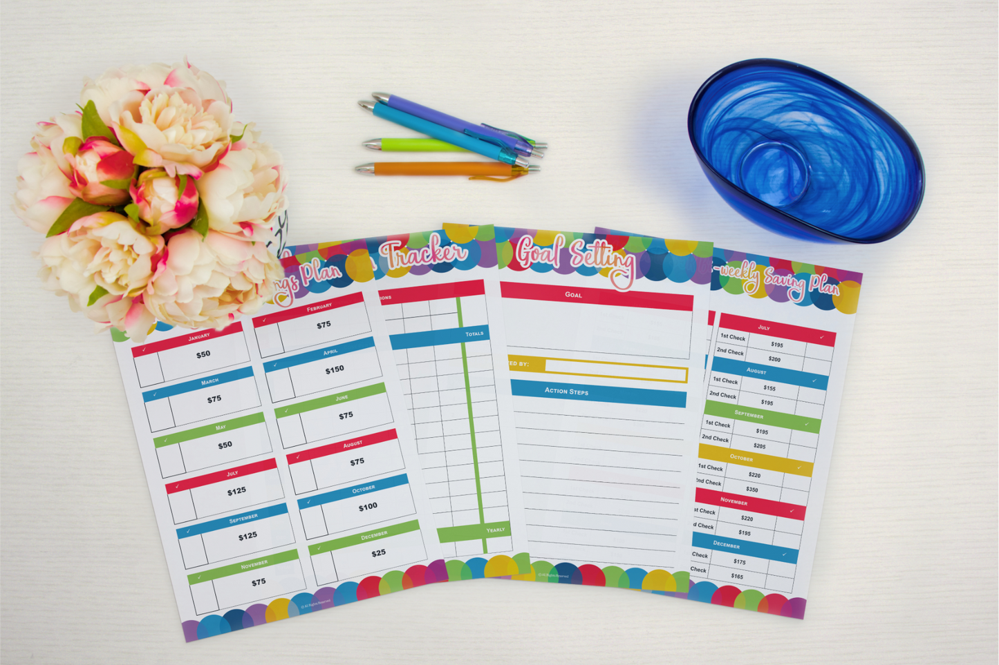 A set of Budget Planner notebooks and pens from Wondermom Shop on a table.