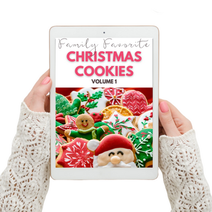 A woman holding an iPad displaying a digital cookbook titled "Family's Favorite Christmas Cookies Digital Cookbook Volume 1" by Wondermom Wannabe.