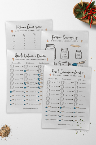 A set of kitchen recipe cards and VIP Vault free printable Kitchen Reference Charts on a table.