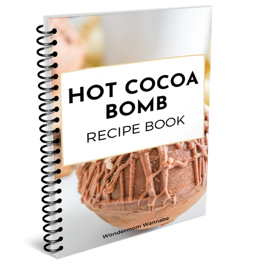 Spiral-bound "Hot Cocoa Bombs Recipe Book" by Wondermom Wannabe, featuring a chocolate-drizzled cocoa bomb cover and packed with tasty recipes for your next sweet treat.