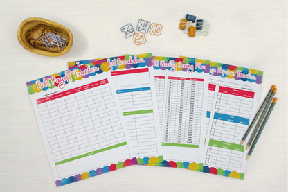 A set of colorful Wondermom Shop Budget Planners and pencils on a white table.